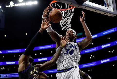 Los Angeles Lakers forward LeBron James and Orlando Magic center Wendell Carter Jr. (34) jump for a rebound during the first half of an NBA basketball game, in Los Angeles.