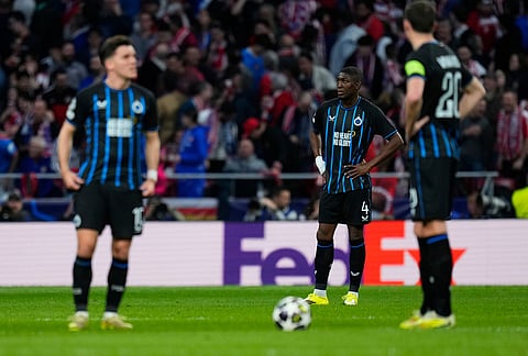 Brugge's Joel Ordonez, background, reacts after a goal against his team during the Champions League play-off second leg soccer match between Atletico Madrid and Club Brugge, in Madrid, Spain.