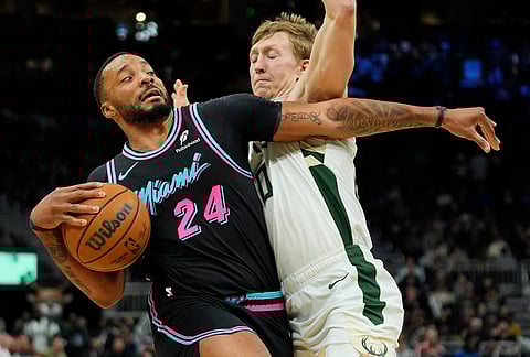 Miami Heat's Norman Powell (24) drives to the basket against Milwaukee Bucks' AJ Green during the second half of an NBA basketball game, in Milwaukee.