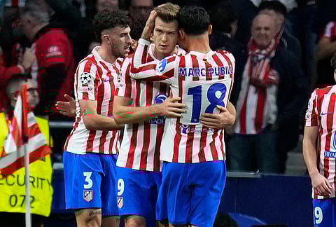 Atletico Madrid's Alexander Sorloth, center, celebrates after scoring the opening goal of his team during the Champions League play-off second leg soccer match between Atletico Madrid and Club Brugge, in Madrid, Spain.