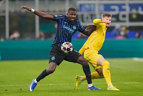Inter Milan's Marcus Thuram, left, vies for the ball with Glimt's Odin Bjortuft during a Champions League playoff soccer match between Inter Milan and Bodo Glimt, at the San Siro stadium in Milan, Italy.