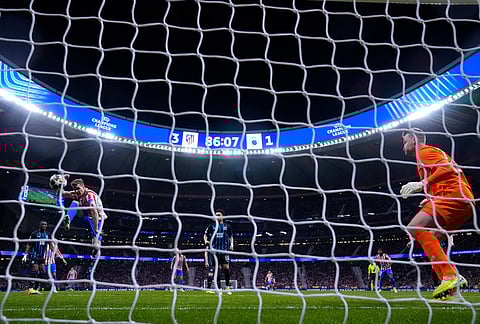 Atletico Madrid's Alexander Sorloth, left, scores his side's fourth goal during the Champions League play-off second leg soccer match between Atletico Madrid and Club Brugge, in Madrid, Spain.