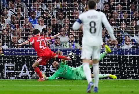 Benfica's Rafa Silva, left, scores the opening goal during the second leg of the Champions League playoff soccer match between Real Madrid and Benfica in Madrid, Spain.