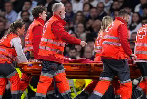 Medics carry Real Madrid's Raul Asencio from the pitch after sustaining an injury during the second leg of the Champions League playoff soccer match between Real Madrid and Benfica in Madrid, Spain.