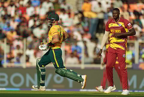 West Indies' Jason Holder, right, looks on as South Africa's captain Aiden Markram runs between the wickets during the T20 World Cup cricket match between South Africa and West Indies in Ahmedabad.