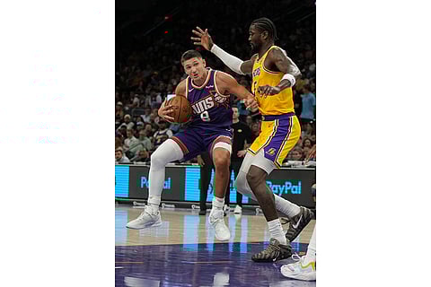 Phoenix Suns guard Grayson Allen (8) drives on Los Angeles Lakers center Deandre Ayton during the second half of an NBA basketball game in Phoenix.