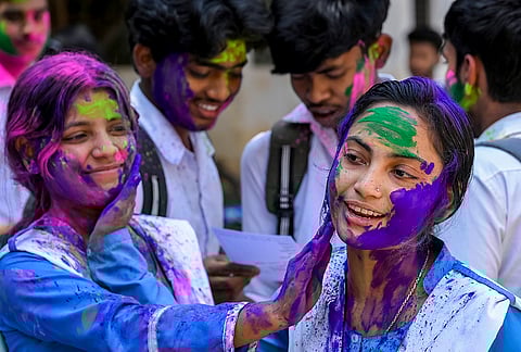 Students play with 'gulal' after appearing for Higher secondary examination, ahead of the Holi festival, in Nadia, West Bengal.