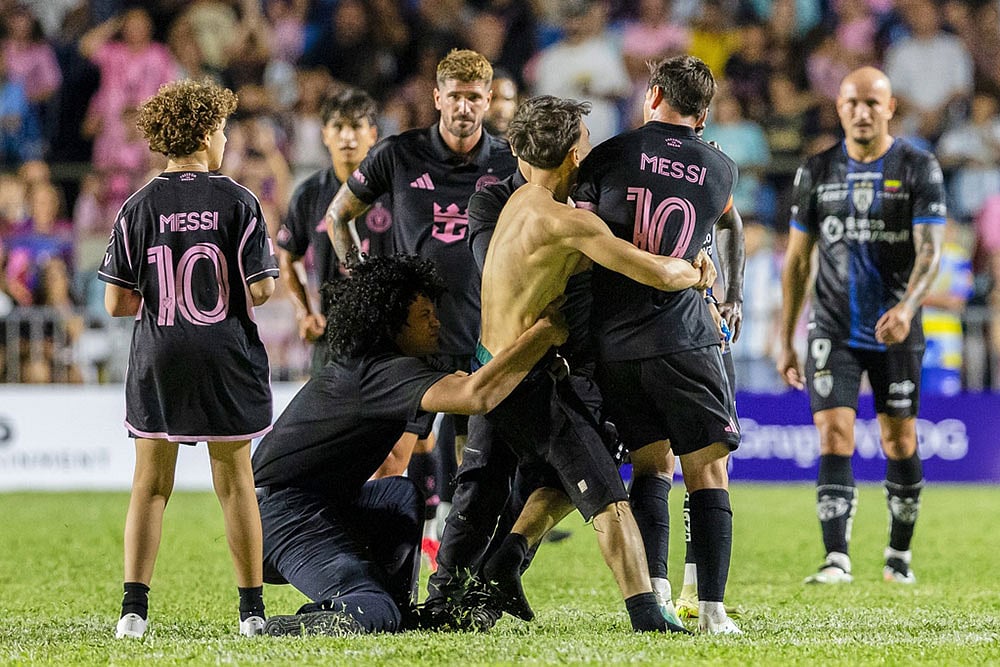 A fan who got onto the field grabs Inter Miami's Lionel Messi at the end of an international friendly soccer match against Ecuador's Independiente del Valle in Bayamon, Puerto Rico. - | Photo: AP/Alejandro Granadillo