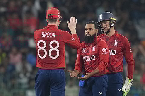 England's Adil Rashid, centre, celebrates with captain Harry Brook, left, the wicket of New Zealand Mark Chapman during the T20 World Cup cricket match between England and New Zealand in Colombo, Sri Lanka.