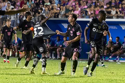 Inter Miami's Lionel Messi grabs the jersey of Jhegson Méndez of Ecuador's Independiente del Valle during an international friendly soccer match in Bayamon, Puerto Rico.