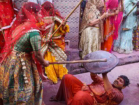 People take part in the Lathmar Holi festival celebrations, in Nandgaon, Mathura.