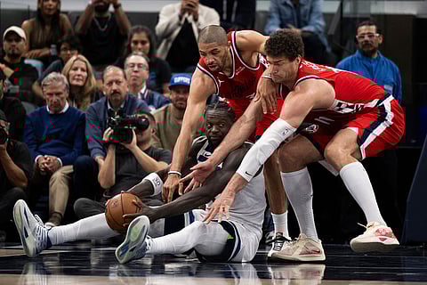 Minnesota Timberwolves forward Julius Randle, bottom left, keeps the ball away from Los Angeles Clippers forward Nicolas Batum, top left, center Brook Lopez, right, during the first half of an NBA basketball game in Inglewood, Calif.