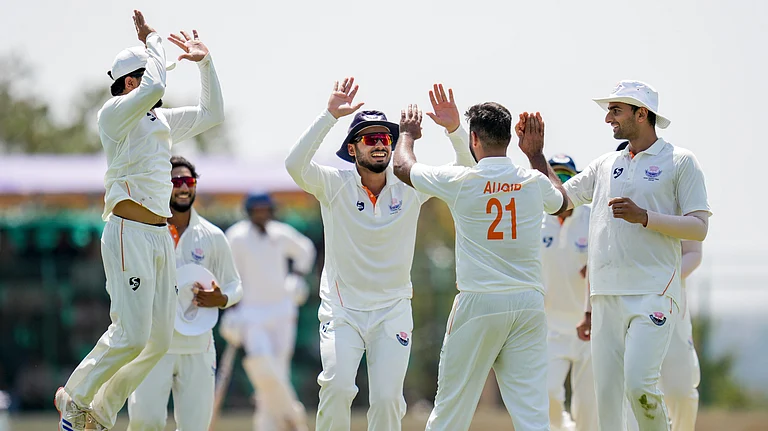 Jammu and Kashmir's Auqib Nabi celebrates with teammates after taking the wicket of Karnataka's Smaran Ravichandran during the third day of the Ranji Trophy 2025-26 final at the KSCA Cricket Stadium. - PTI