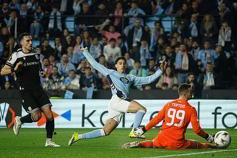 Celta's Jones El-Abdellaou, center, tries a shot next to PAOK's goalkeeper Antonis Tsiftsis during the second leg of the Europa League playoff soccer match between Celta Vigo and PAOK in Vigo, Spain.