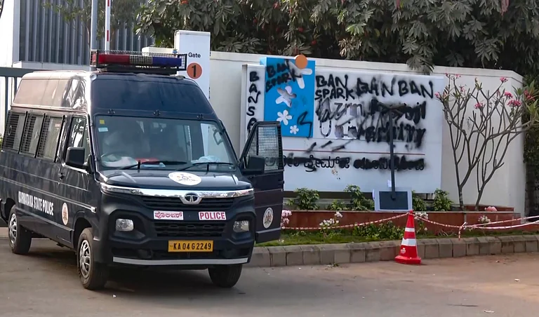 A Karnataka State Police vehicle stationed outside the Azim Premji University campus after alleged vandalism and graffiti reading 'Ban Spark' appeared on the wall following a protest by Akhil Bharatiya Vidyarthi Parishad activists, at Sarjapur, in Bengaluru - PTI