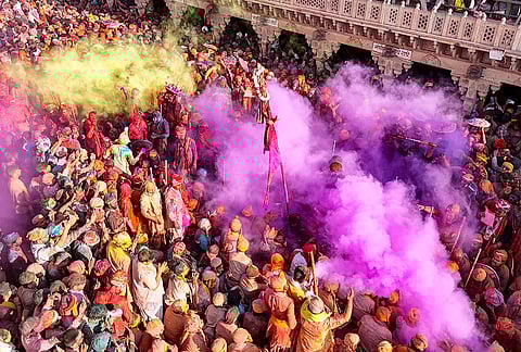 People celebrate amid ‘Holi’ festivities, near Shri Nand Baba Temple, in Nandgaon, Mathura.