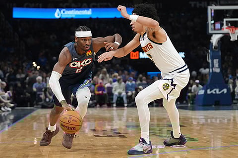 Oklahoma City Thunder guard Shai Gilgeous-Alexander, left, drives past Denver Nuggets guard Julian Strawther, right, during the second half of an NBA basketball game in Oklahoma City.