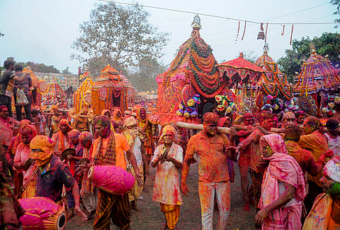 People carry 'bimanas', decorated palanquins, of Lord Krishna and his divine consort Radha during the 'Dola Jatra' festival, marking the beginning of the 'Holi' festival, at a village on the outskirts of Bhubaneswar, Odisha.