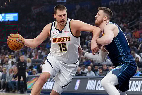 Denver Nuggets center Nikola Jokic, left, drives past Oklahoma City Thunder center Isaiah Hartenstein, right, during the first half of an NBA basketball game in Oklahoma City.