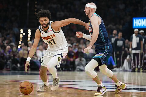 Denver Nuggets guard Jamal Murray, left, drives past Oklahoma City Thunder guard Alex Caruso, right, during the first half of an NBA basketball game in Oklahoma City.