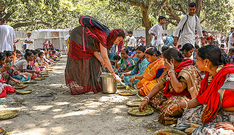 ISKCON officials serve 'Radha-Krishna prasadam' to people ahead of the 'Holi' festival celebration, at Santipur, in Nadia district, West Bengal.