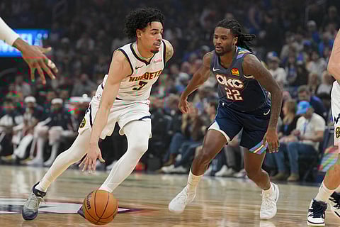 Denver Nuggets guard Julian Strawther, left, gets past Oklahoma City Thunder guard Cason Wallace (22) during the first half of an NBA basketball game in Oklahoma City.