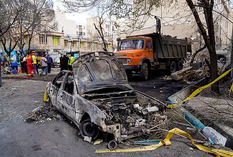A damaged car remains on the ground in the aftermath of an Israeli-U.S. strike in Tehran, Iran.