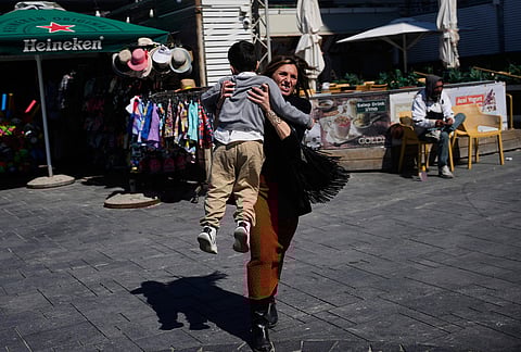 People rush to take shelter as warning sirens sound following missile fired towards Israel, in Tel Aviv, Israel.