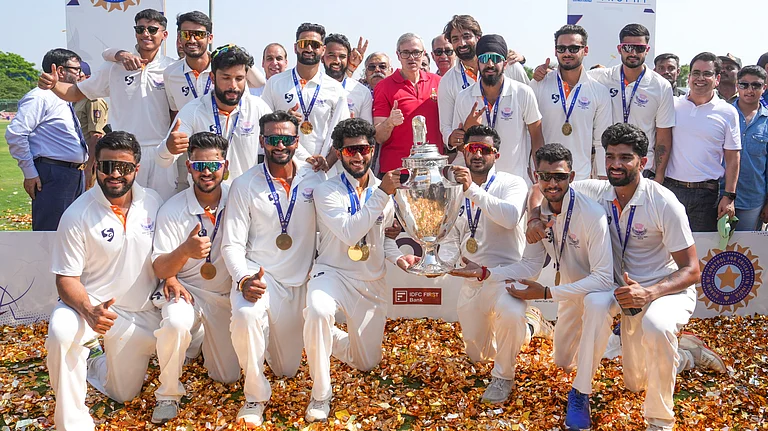 Jammu and Kashmir players pose with the trophy after the team's victory in the Ranji Trophy 2025-26 final against Karnataka, at KSCA Stadium in Hubballi. - PTI