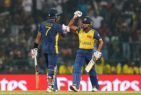 Sri Lanka's captain Dasun Shanaka, left, celebrates his fifty runs with batting partner Dunith Wellalage during the T20 World Cup cricket match between Pakistan and Sri Lanka in Pallekele, Sri Lanka.