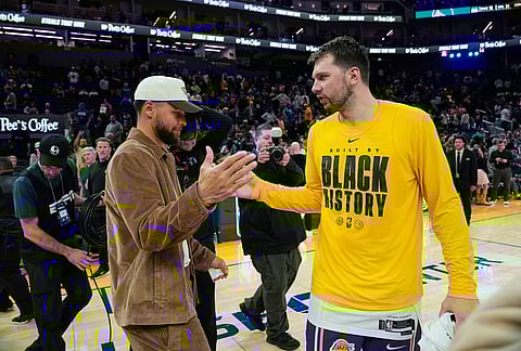 Golden State Warriors' Stephen Curry, left, and Los Angeles Lakers guard Luka Doncic shake hands after an NBA basketball game in San Francisco.