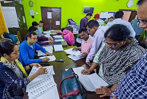 People check their names in the voters' list after publication of the post-Special Intensive Revision (SIR) electoral rolls, in Birbhum, West Bengal.