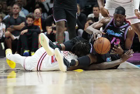 Miami Heat center Bam Adebayo (13) sndf Houston Rockets forward Dorian Finney-Smith, left go for a loose ball during the second half of an NBA basketball game, in Miami.