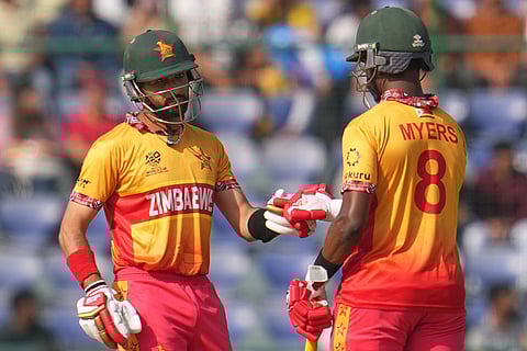 Zimbabwe's captain Sikandar Raza, left, celebrates with Dion Myers after hits a six during the T20 World Cup cricket match between South Africa and Zimbabwe in New Delhi.