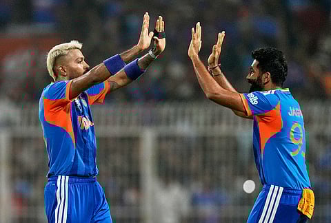 India's Hardik Pandya, left, celebrates with teammate Jasprit Bumrah the wicket of West Indies' Sherfane Rutherford during the T20 World Cup cricket match between India and West Indies in Kolkata.