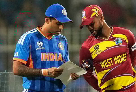 India's captain Suryakumar Yadav, left, shows his team list to West Indies' captain Shai Hope before the coin toss of the T20 World Cup cricket match between India and West Indies in Kolkata.