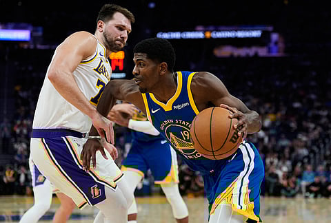 Golden State Warriors guard Nate Williams (19) moves the ball while defended by Los Angeles Lakers guard Luka Doncic (77) during the second half of an NBA basketball game in San Francisco. 