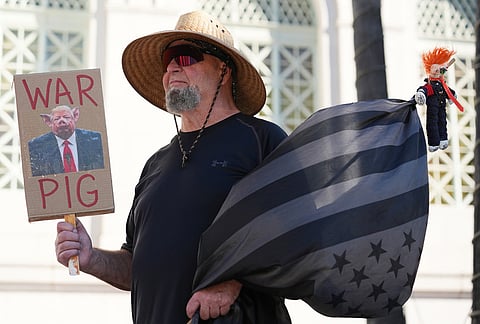 A protester holds a sign during a demonstration in reaction to the U.S. and Israeli strikes on Iran in Los Angeles. 