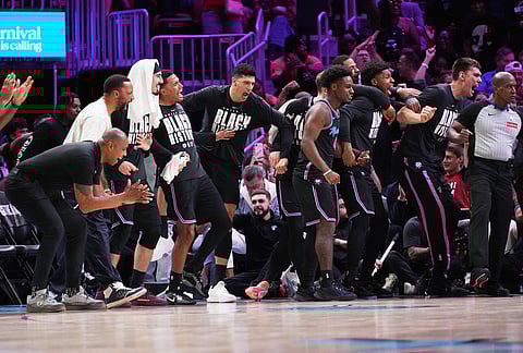 Miami Heat players react after forward Andrew Wiggins scored during the second half of an NBA basketball game against the Houston Rockets, in Miami. 