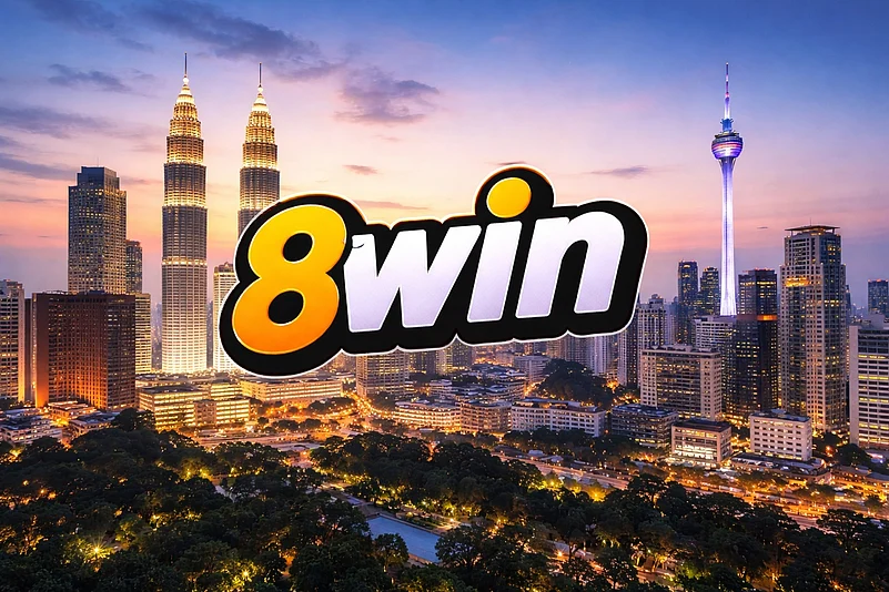 The 8win logo in yellow and white text centered over the Kuala Lumpur skyline at dusk.