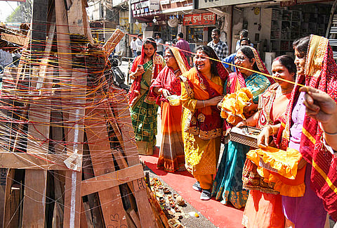 Women perform rituals during the 'Holika Dahan' festival, in Patna.
