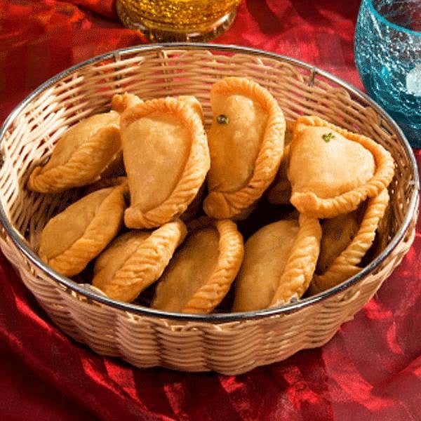 Wicker basket filled with golden fried gujiya