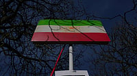 | Photo: AP/Kin Cheung : A historic Iranian national flag is displayed by protesters outside the Iranian Embassy in London, Monday, March 2, 2026. 