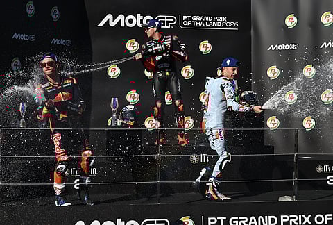 From left, second placed Spain's rider Pedro Acosta, MotoGP winner Italy's rider Marco Bezzecchi and third placed Spain's rider Raul Fernandez celebrate on the podium after the MotoGP at the Chang International Circuit in Buriram, Thailand.