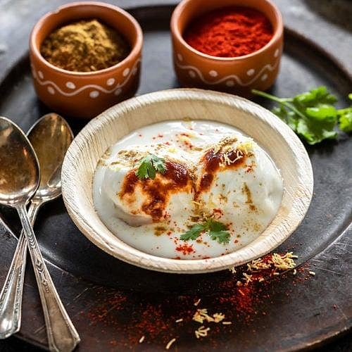 Dahi vada in a bowl with yogurt and chutney