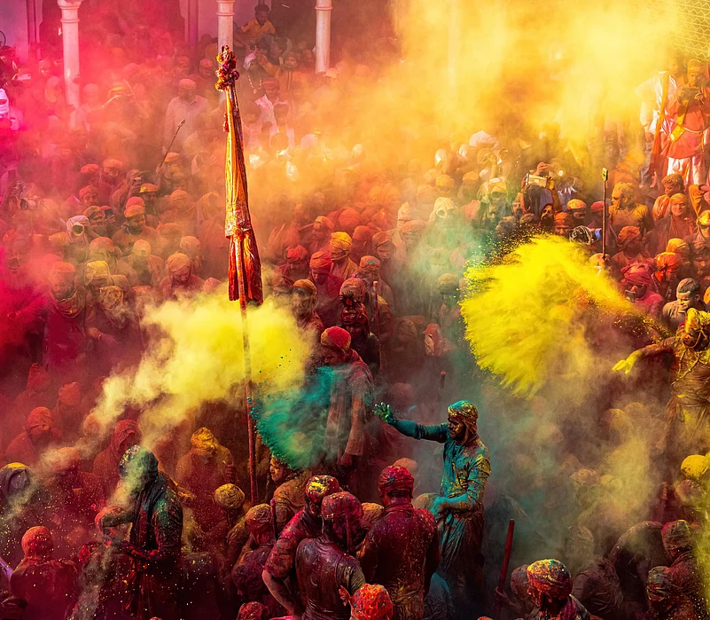 Vibrant crowd celebrating Holi with color powder