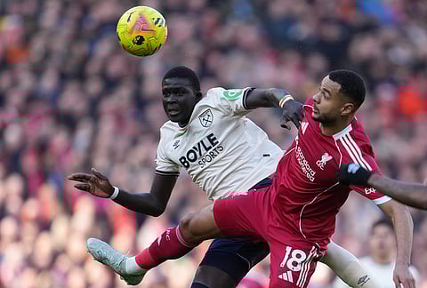 West Ham's El Hadji Malick Diouf, left, and Liverpool's Cody Gakpo jump for the ball during the Premier League soccer match between Liverpool and West Ham United in Liverpool, England.