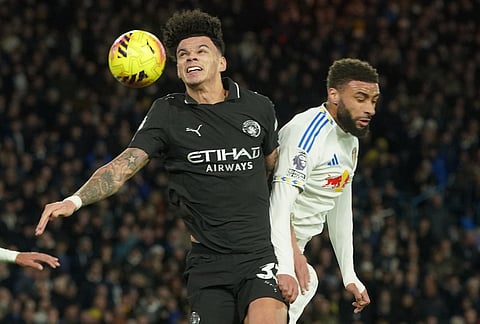 Manchester City's Nico O'Reilly, left, and Leeds' Jayden Bogle jump for the ball during the Premier League soccer match between Leeds United and Manchester City in Leeds, England.
