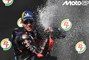 | Photo: AP/Kittinun Rodsupan : MotoGP winner Italy's rider Marco Bezzecchi, celebrates on the podium after the MotoGP at the Chang International Circuit in Buriram, Thailand.