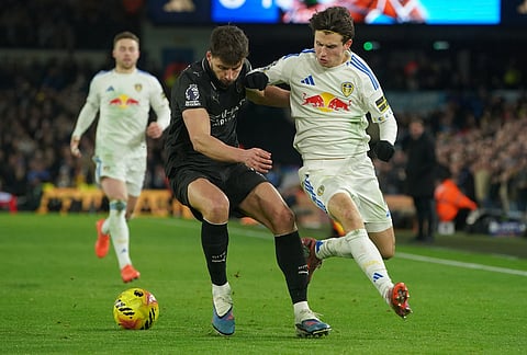 Manchester City's Ruben Dias, left, and Leeds' Brenden Aaronson fight for the ball during the Premier League soccer match between Leeds United and Manchester City in Leeds, England.